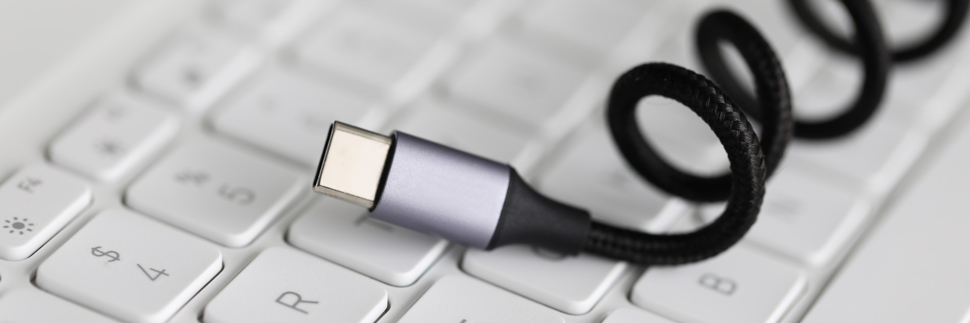 Usb type c cable against laptop keyboard background.